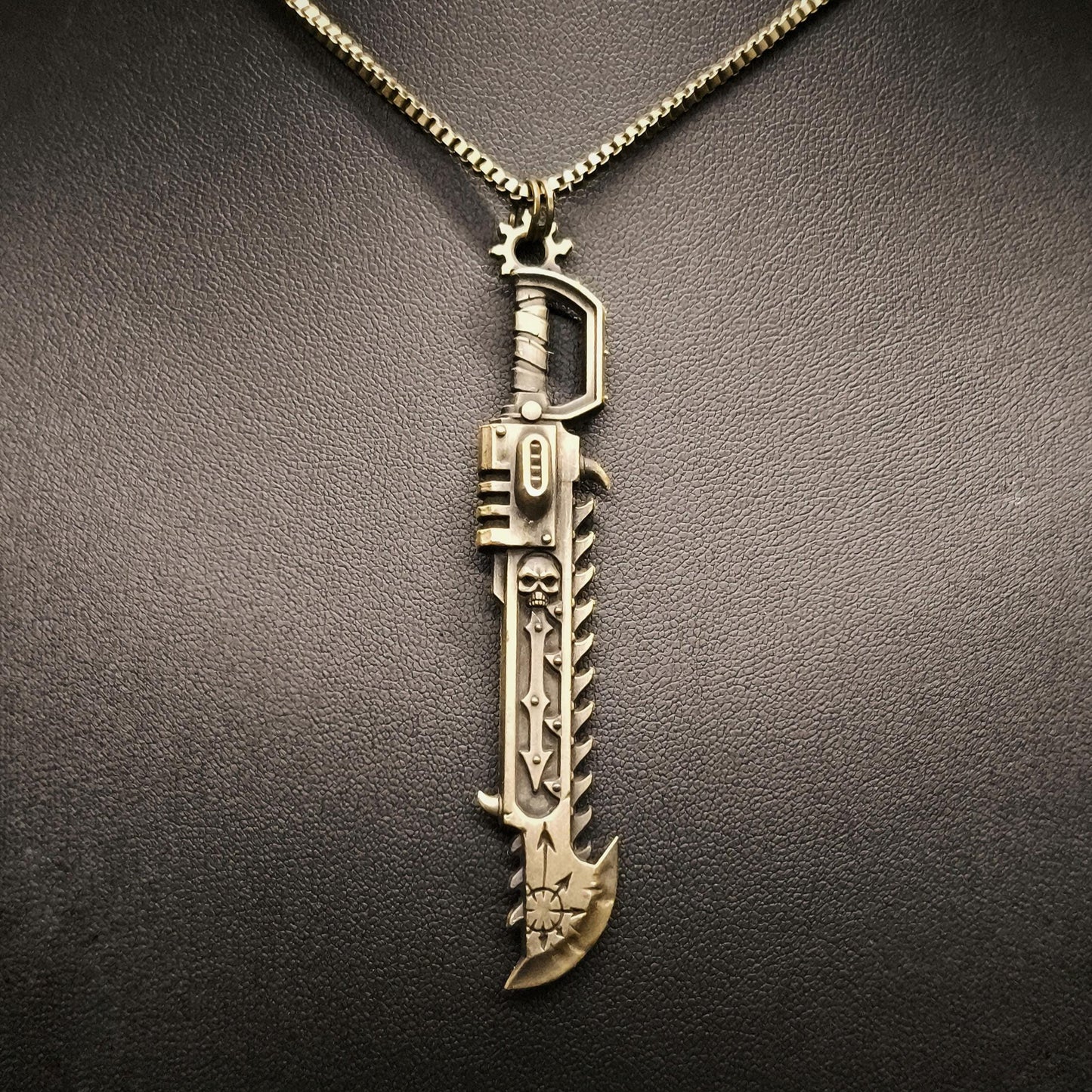Gold sword-shaped pendant on a black background