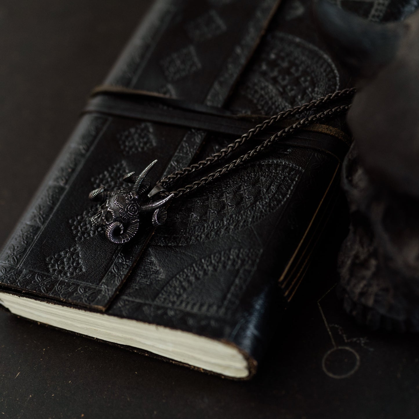 Black leather notebook with decorative elements on a dark background