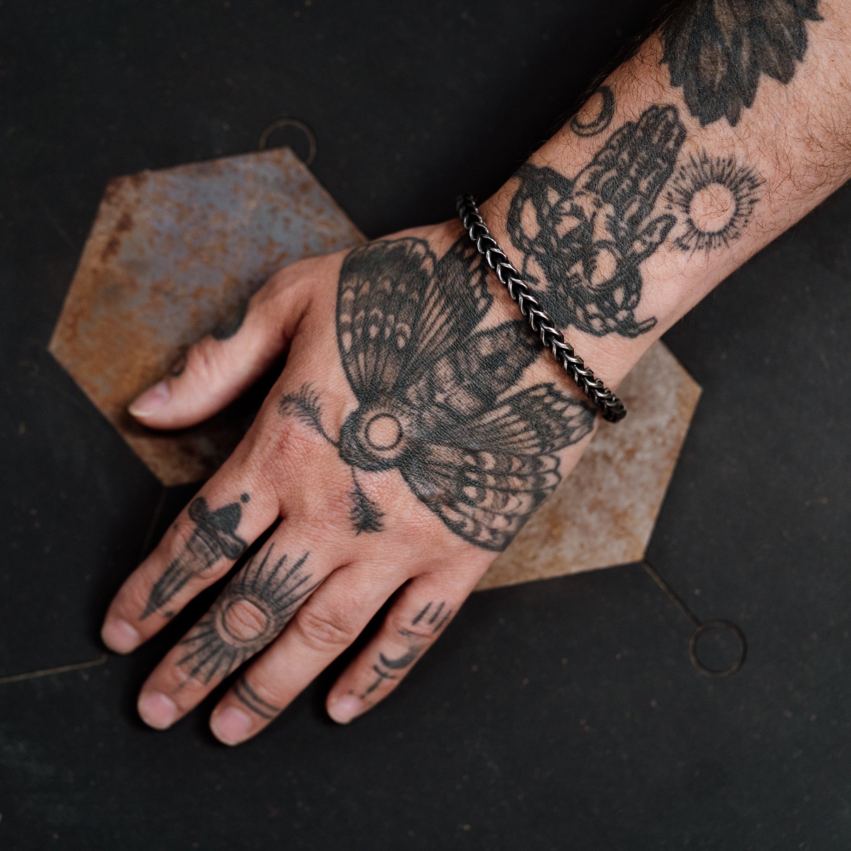 Hand with detailed tattoos on a dark background