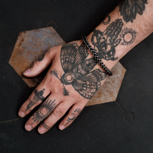 Hand with detailed tattoos on a dark background